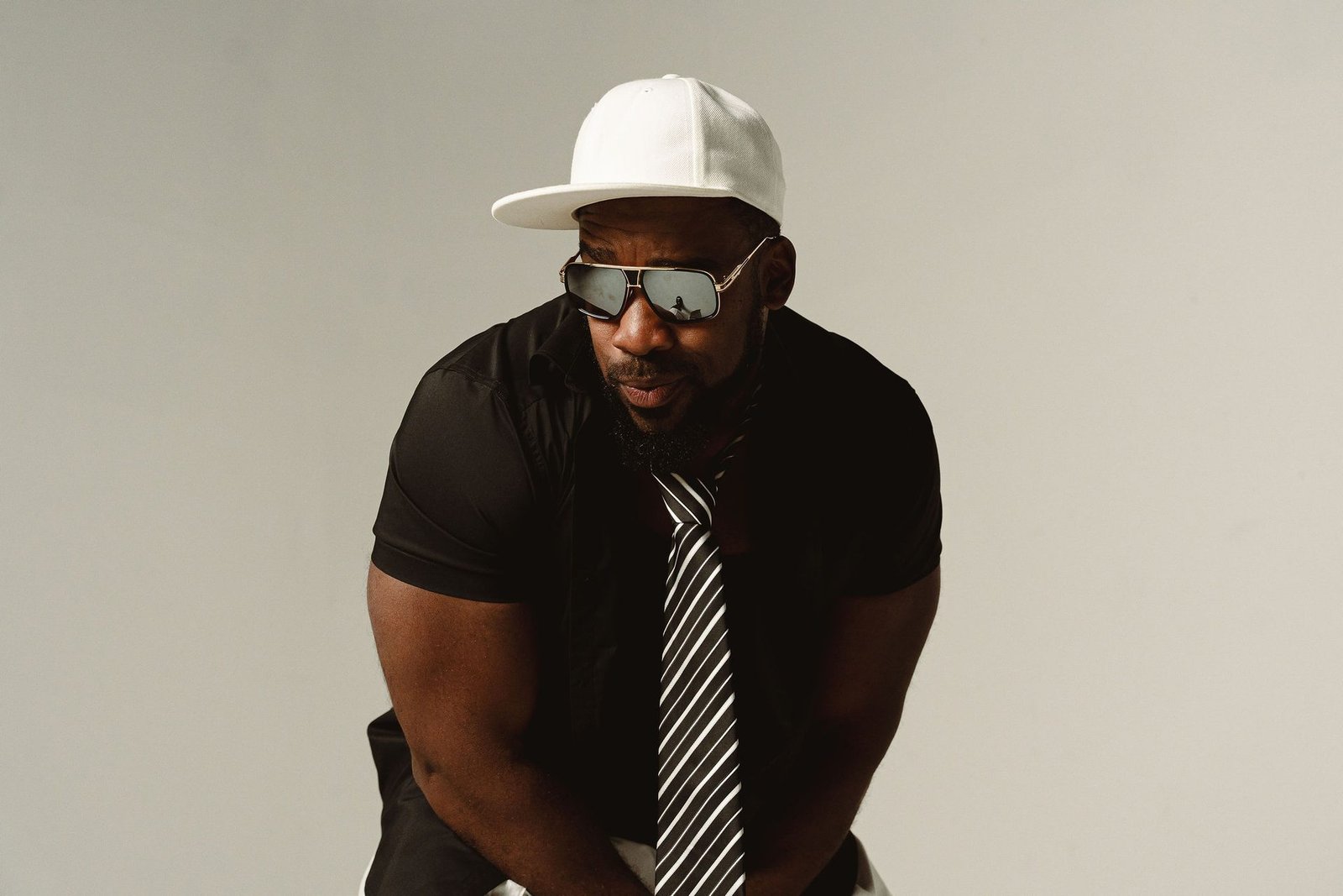 Bad Juju in a white cap and mirrored sunglasses